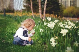Bilete av eit barn som luktar på ein blom
